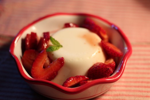 Panna cotta served with sliced strawberries.
