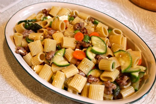 Mix pasta with vegetables and sausage in a baking dish.
