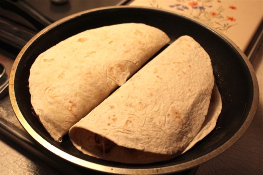 Place two quesadillas at a time in a large fry pan, and toast to melt the cheese. 