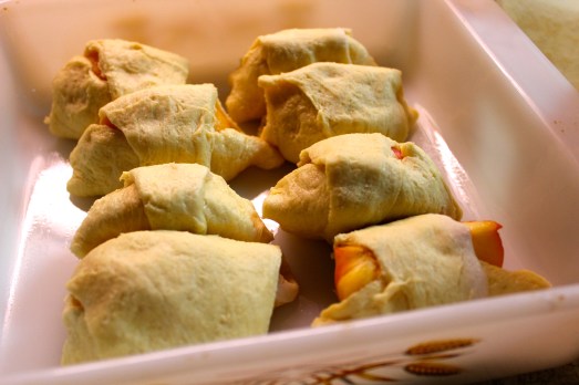 Wrap each peach quarter in  crescent roll dough.