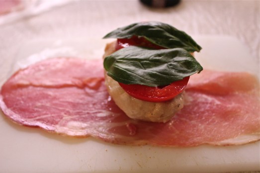 Place tomato slices and basil on top of chicken, then wrap prosciutto over the top.