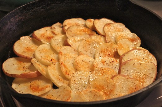 Roast sliced potatoes in a heavy oven-ready pan. 