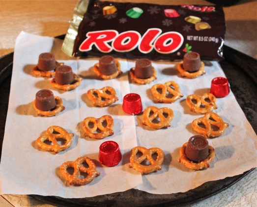 Lay out pretzels on a baking sheet, top each one with a candy.