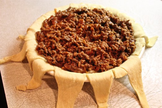 Layer cooked beef and sauce on top of cheese.