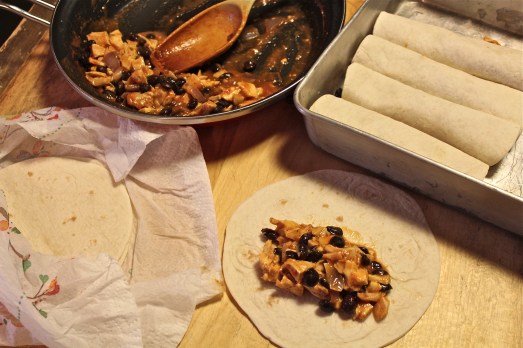 Rolling up the tortillas with filling.