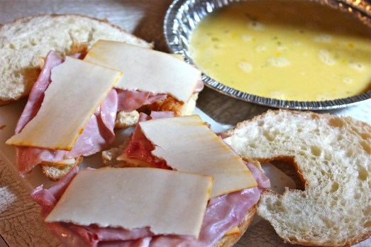 Layer up the ham and cheese, then dip the sandwich in egg.