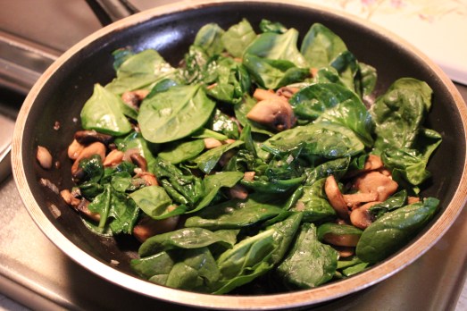 Mushrooms and spinach added to skillet.