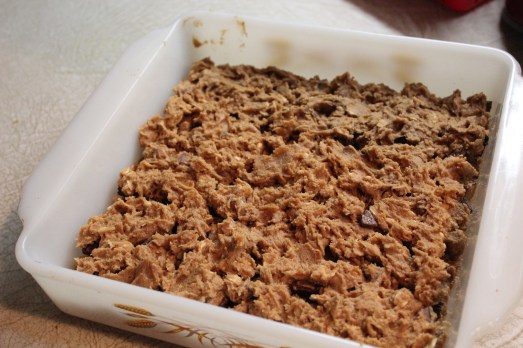 About half the dough on the bottom, a layer of Reese's cups, and the remaining dough on top.