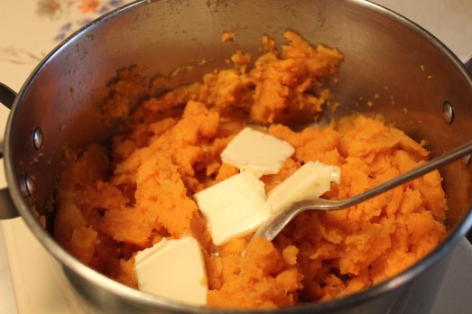 Add butter to hot potatoes so it can melt in, then mash.